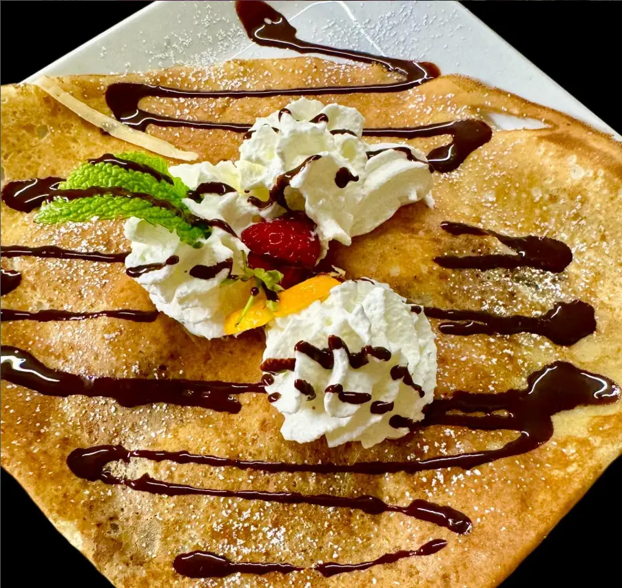 Crêpe garnie de chantilly, sauce chocolat et fraise